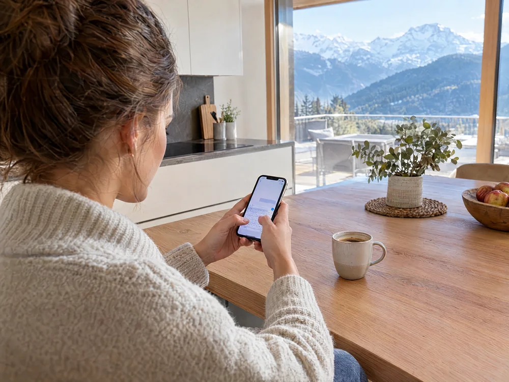 Ein Gast tippt in der Ferienwohnung eine Frage ins Handy